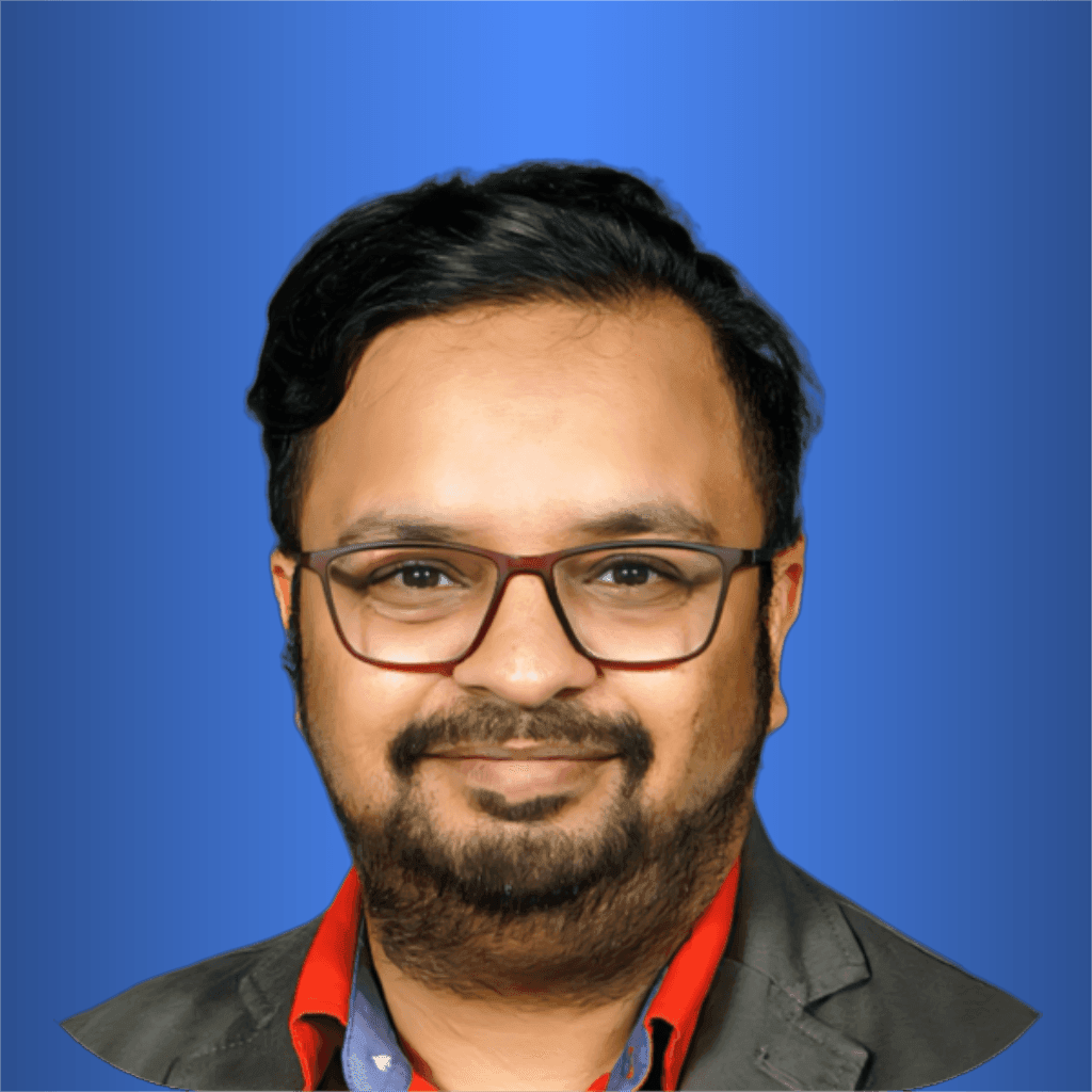 Chinmaya wearing a red shirt with a black blazer in a portrait against a blue background. | Chinmaya Sadangi | Digii Ninja